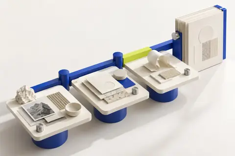Three work tables joined by one blue rail, passing project materials along to a finished book